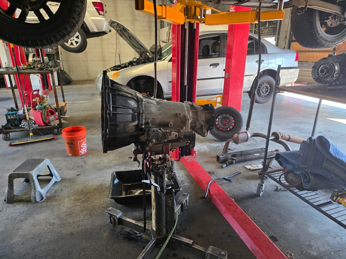 A vehicle up on the lift being serviced at RPM 1 Stop Auto Shop in Denver