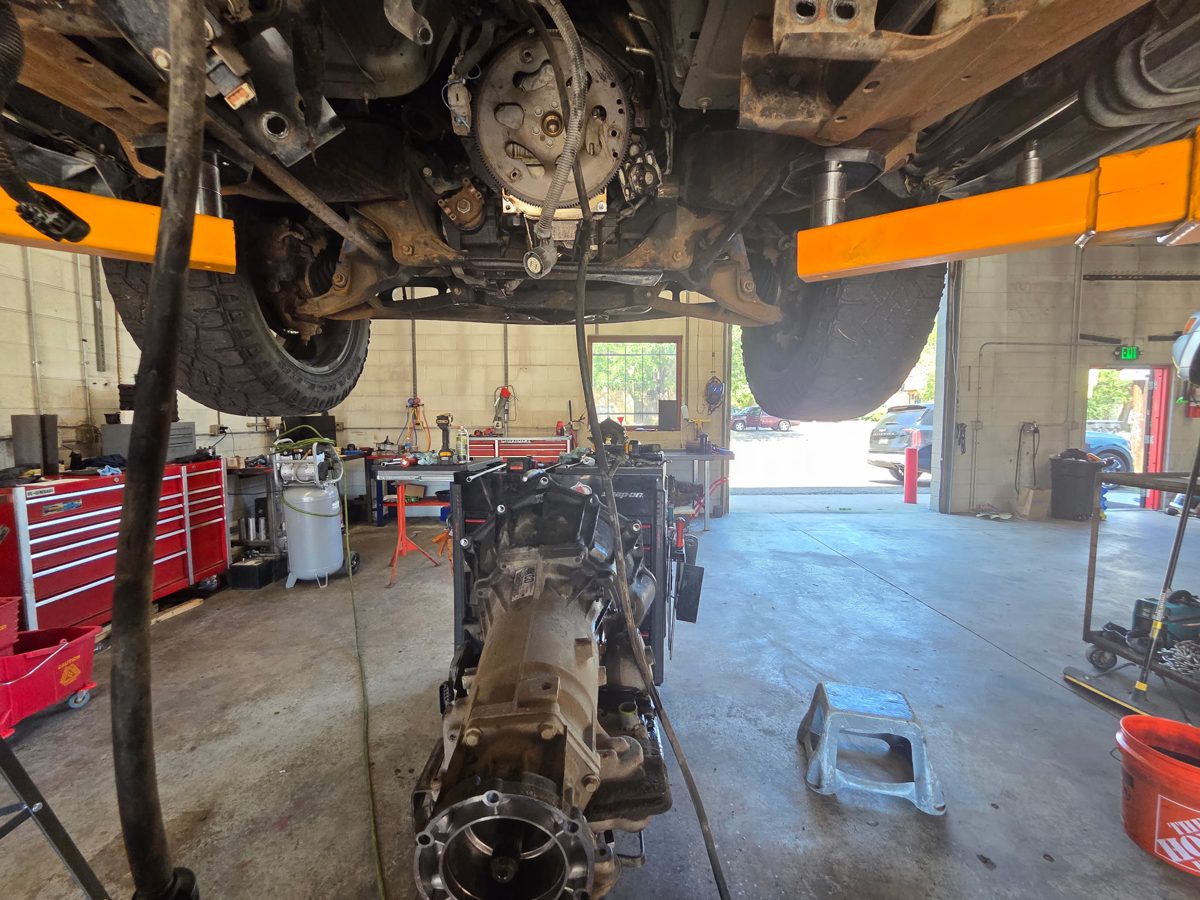 A vehicle raised on the lift for repair at RPM 1 Stop Auto Shop
